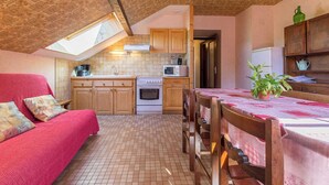 Une cuisine chaleureuse avec des meubles en bois, un dosseret carrelé et une lucarne.