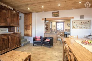 A cozy kitchen with wooden cabinets, a dining area with a wooden table, and a kitchen island.