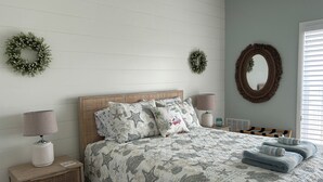 Een slaapkamer met een bed, twee nachtkastjes, een lamp, een spiegel en twee wandkransen.