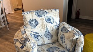 Een stoel met een bekleding met een blauw-wit schelpenpatroon.