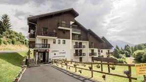 Un edificio de varios pisos con balcones, una tienda de esquí y un cartel que indica un lugar de esquí.