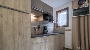 Una cocina moderna con armarios de madera, un lavamanos de acero inoxidable y un ventanal con vistas.