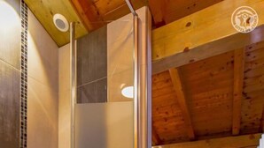 A modern bathroom with a glass shower enclosure, a tiled floor, and wooden ceiling beams. - CHALET LES AROLLES - HAUTELUCE LES SAISIES (HAUTELUCE LES SAISIES)