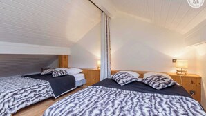 Ein Schlafzimmer mit zwei Betten, Holz-Kopfteilen und Nachttischlampen.