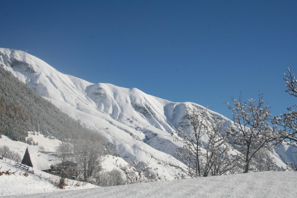 A snow-covered mountain landscape with a clear sky.