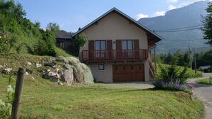 A two-story house with a balcony, a garage, and a grassy yard. - LA FONTANETTE - PORTE DE SAVOIE (PORTE DE SAVOIE)