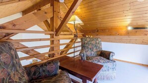A wooden interior with a high ceiling, a wooden table, and two patterned armchairs. - LA FONTANETTE - PORTE DE SAVOIE (PORTE DE SAVOIE)