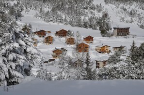 A snow-covered mountain resort with wooden cabins and a hotel. - L'ORCHIS VANILLÉ - VAL-CENIS (VAL-CENIS)
