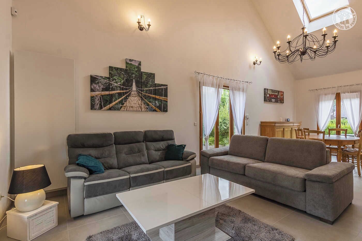 A spacious living room with two sofas, a coffee table, and a dining area with a table and chairs.