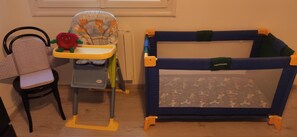 A child-friendly space with a high chair and playpen for little ones.