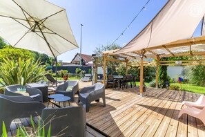 A wooden deck with outdoor seating, including chairs and tables, under a pergola. - La Cigale Et La Fourmi - The Pigeon House (AIX LES BAINS)
