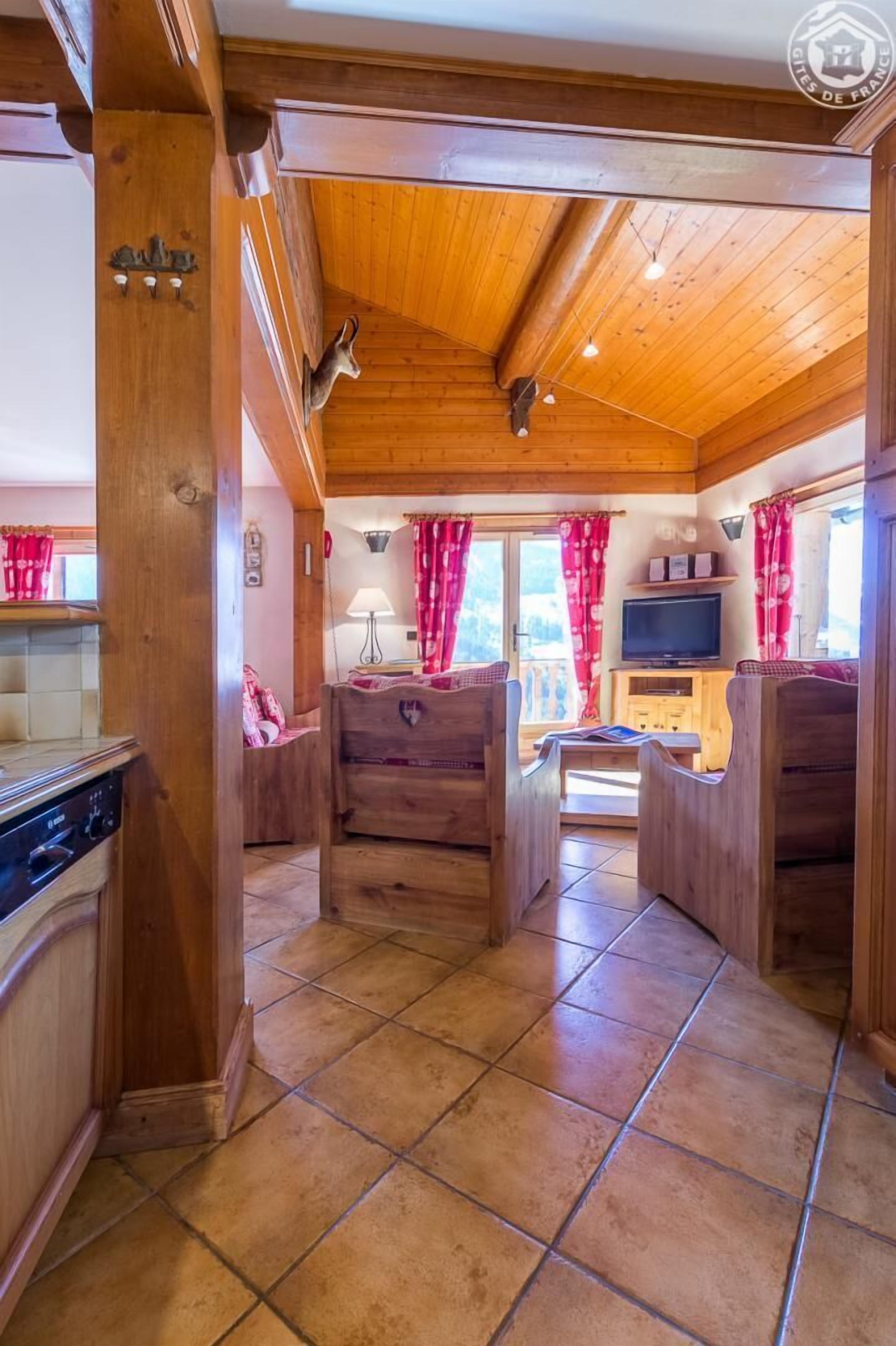 Un intérieur en bois comprenant un coin cuisine, une table à manger et un téléviseur.