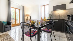 Una cocina moderna con área de comedor, con un ventanal grande, una cafetera y una mesa de comedor con sillas.