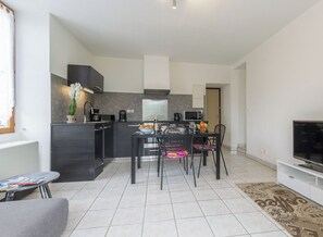 A modern apartment with a kitchen, dining area, and living room.