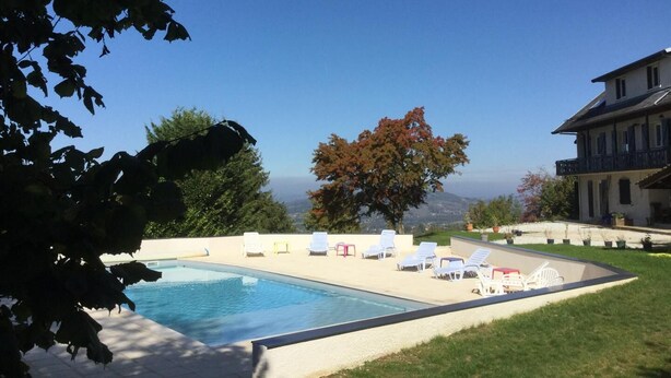 A swimming pool with lounge chairs, a large tree, and a view of a mountain range. - PRE CHARVILLE - LE REVARD (TREVIGNIN)