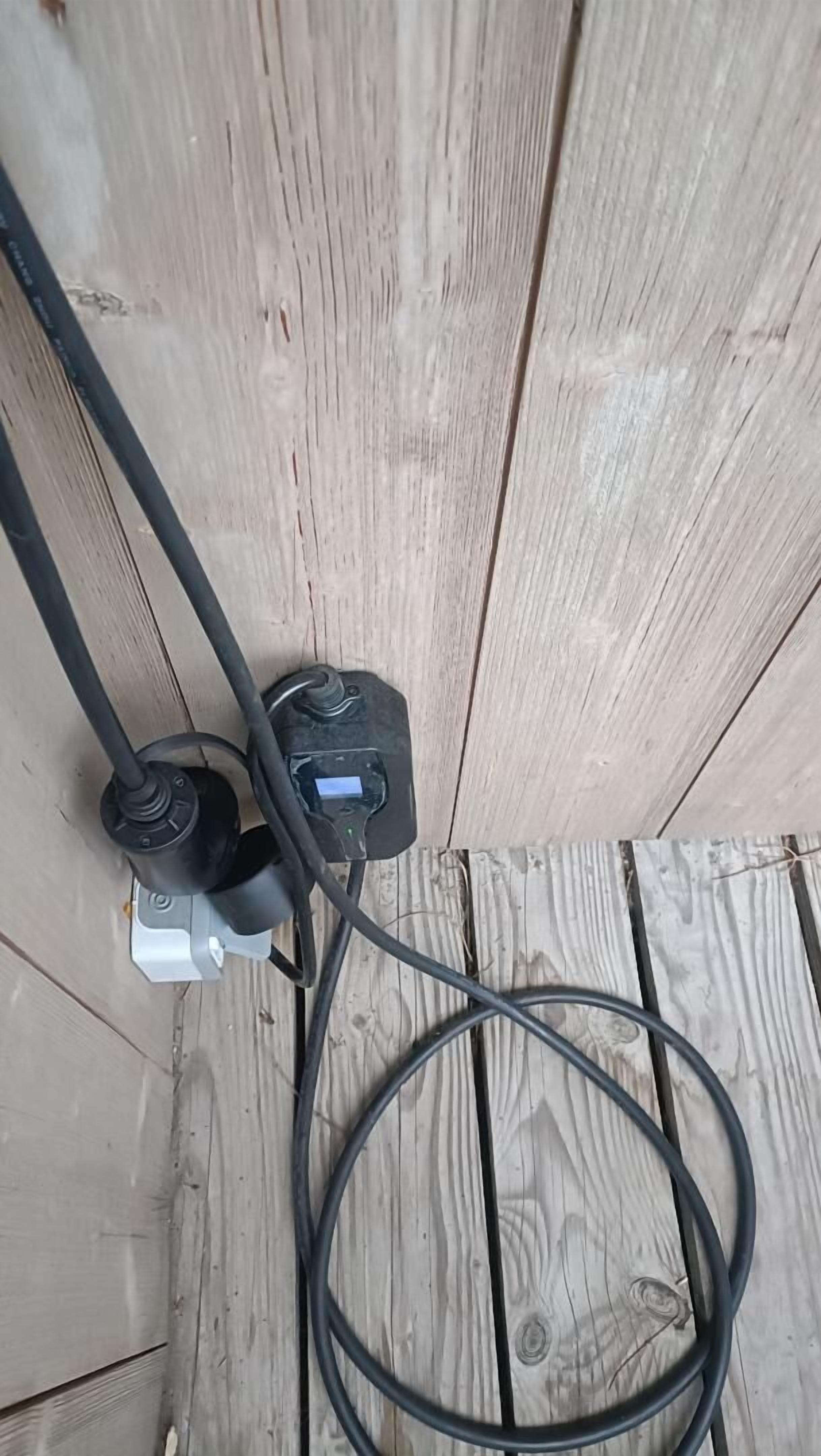 Prese di corrente con due spine, un cavo e un interruttore su una superficie in legno.