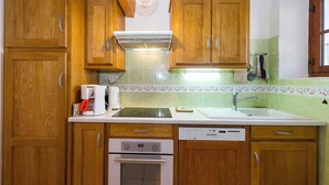A kitchen with wooden cabinets, a built-in oven, a dishwasher, and a coffee maker. - LA CASCADE - LA GIETTAZ (LA GIETTAZ)