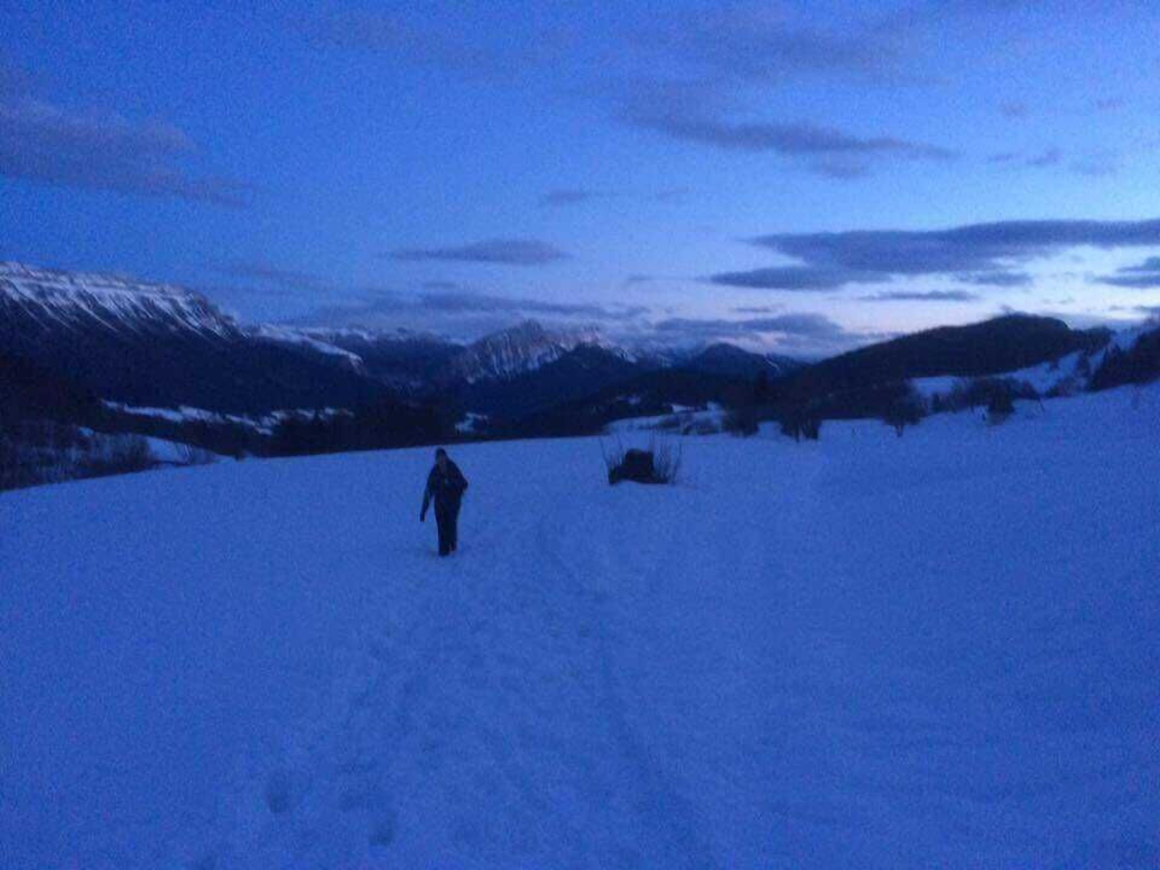 Un paysage enneigé où l’on voit une personne qui marche.