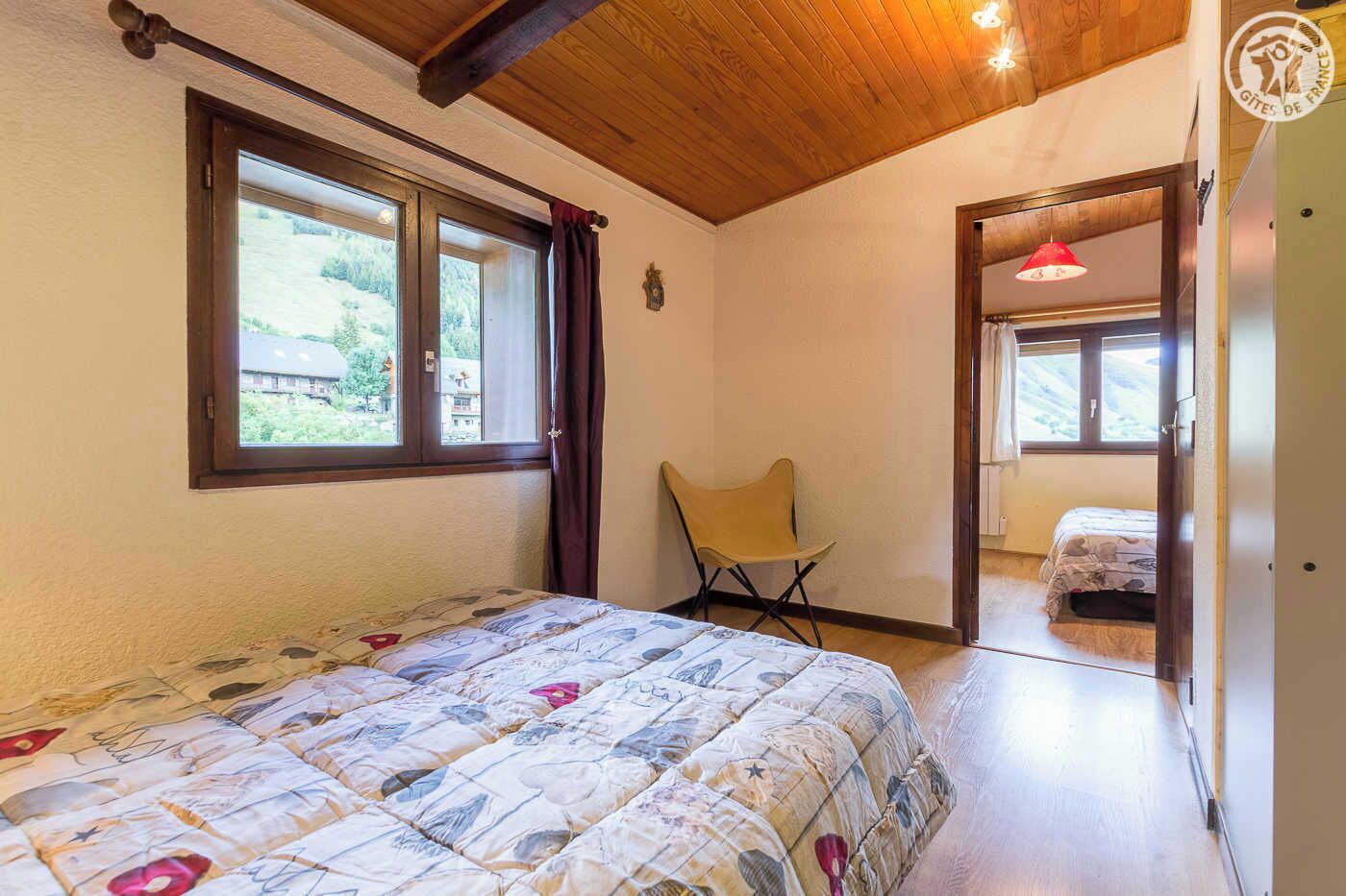 Quarto com uma cama, uma cadeira e uma janela.