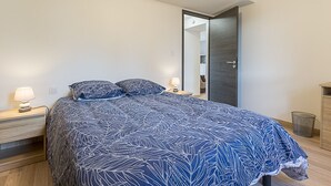 A bedroom with a bed, two bedside lamps, a nightstand, a wardrobe, and a mirror. - LES LILAS - LA BIOLLE (LA BIOLLE)