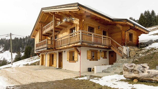 A wooden chalet with a balcony, stone steps, and a view of a snowy mountain. - CHALET FIASSE - HAUTELUCE LES SAISIES (HAUTELUCE LES SAISIES)