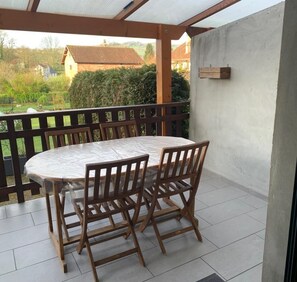 Relax in this serene outdoor space with a round table and four comfortable chairs.