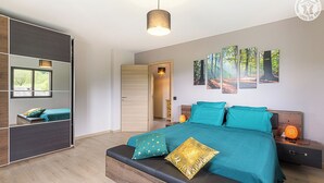 A modern bedroom with a large bed, a wardrobe, and a mirror. - L'OREE DU LAC - LES MOLLETTES (LES MOLLETTES)