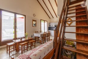 Enjoy meals in the dining area with a wooden table and chairs, and take in the view from the large window.