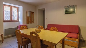 Un comedor con mesa de madera, sillas, un banco y una cesta.