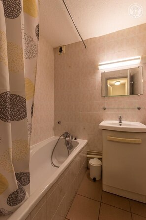 Ein Badezimmer mit Badewanne, Waschbecken und Spiegel.
