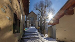 Una calle estrecha cubierta de nieve con una iglesia al fondo.