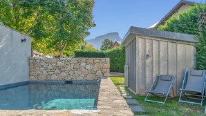 A backyard with a swimming pool, stone wall, and a wooden shed. - LA GRANGE A ROGER - MYANS (MYANS)