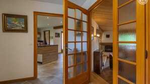 A spacious living area with a wooden door leading to a kitchen, a dining area, and a view of a mountain landscape. - CHALET WAPITI - NOTRE DAME DE BELLECOMBE (NOTRE DAME DE BELLECOMBE)