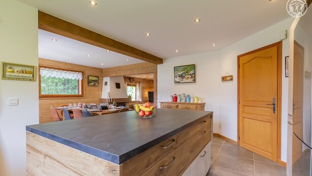 A spacious kitchen with a central island, wooden cabinetry, and a large window. - CHALET WAPITI - NOTRE DAME DE BELLECOMBE (NOTRE DAME DE BELLECOMBE)