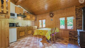 A wooden cabin with a kitchen, dining area, and a fireplace. - LES MARMOTTES - LES BELLEVILLE (LES BELLEVILLE)