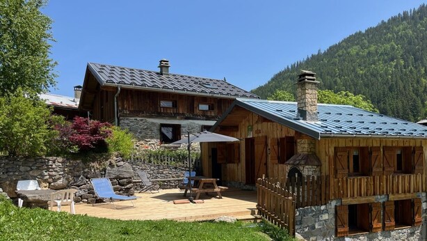 A wooden cabin with a stone foundation, a deck, and a stone chimney. - LES MARMOTTES - LES BELLEVILLE (LES BELLEVILLE)