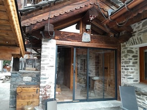 A wooden building with a stone facade, a wooden door, and a glass entrance.