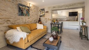 A living room with a sofa, coffee table, and artwork on the walls. - L'ETERNELLE - TRAIZE (TRAIZE)