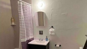 Une salle de bain avec une baignoire, un lavabo, des toilettes et un miroir.