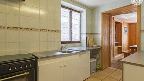 Une cuisine équipée d’une cuisinière, d’un évier et d’une fenêtre.