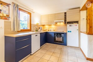 A compact kitchen with a dishwasher, oven, and a built-in stove. - LE VIROLET - BEAUFORT ARECHES (BEAUFORT ARECHES)