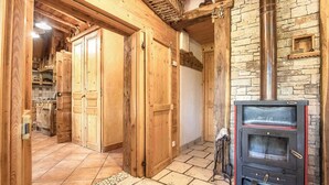 A wooden interior with a stone wall and a fireplace.