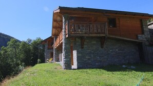 A two-story stone building with a wooden balcony.