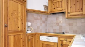 A kitchen with wooden cabinets, a coffee maker, and a dishwasher. - TRIOLET - AUSSOIS - Gîte (AUSSOIS)
