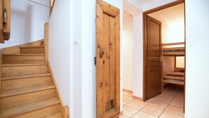 A wooden staircase leading to a room with a wooden door and a bunk bed. - TRIOLET - AUSSOIS - Gîte (AUSSOIS)