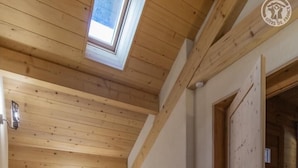 Un escalier en bois avec un puits de lumière, une porte et un luminaire.