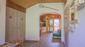 A wooden interior with a kitchen, a dining area, and a living room with a sofa. - LE PAMYDA - HAUTELUCE LES SAISIES (HAUTELUCE LES SAISIES)