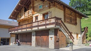 A two-story log cabin with a balcony, stone foundation, and a motorcycle parked in front. - LE PAMYDA - HAUTELUCE LES SAISIES (HAUTELUCE LES SAISIES)