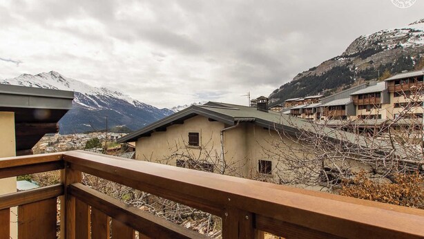 A wooden balcony overlooking a mountainous landscape with traditional buildings. - LE BARBIER - AUSSOIS (AUSSOIS)