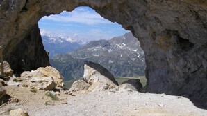 A rocky cave entrance with a view of snow-capped mountains. - LE BARBIER - AUSSOIS (AUSSOIS)